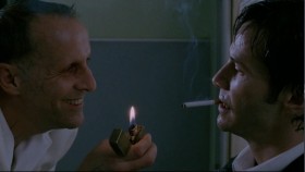 - Hello, John. John, hello! You're the one soul I would come up here to collect myself.
- So I've heard.You mind?
- Oh, go... Go right ahead. I've got stock.
- Coffin nail.
- Very fitting, John. You know, when you cut too deep, you cut the tendons... finger movement goes out the window. Let me help you. See?