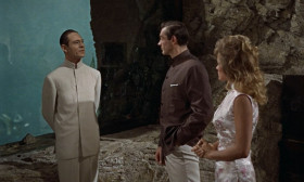 - One million dollars, Mr. Bond. You were wondering what it cost.
- As a matter of fact, I was.
- Forgive my not shaking hands. It becomes a bit awkward with these. A misfortune. You were admiring my aquarium.
- Yes. It's quite impressive.
- A unique feat of engineering, if I may say so. I designed it myself. The glass is convex, 10 inches thick, which accounts for the magnifying effect. Minnows pretending they're whales.
- Just like you on this island, Dr. No.
- It depends, Mr. Bond, on which side of the glass you are.