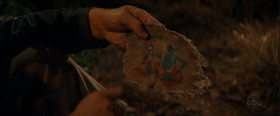 - Why are you dragging us off to this deserted palace? Fortune and glory?
- Fortune and glory... Well... this is a piece of an old manuscript. This pictograph represents Sankara, a priest. Gentle. Gentle. This is hundreds of years old.
- Is that some kind of writing?
- Yeah, it's Sanskrit. It's part of the legend of Sankara. He climbs Mount Kalisa where he meets Siva, the Hindu god.
- That's Siva? And what's he handing the priest?
- Rocks. He told him to go forth and combat evil. And to help him, he gave him five sacred stones with magical properties.
- Magic rocks? My grandpa was a magician. He spent his entire life with a rabbit in his pocket and pigeons up his sleeves. He made a lot of children happy and died a very poor man.