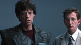 <b>Michelette:</b> - McCandless is no more.
<b>Furlong:</b> - Wait... I'm McCandless. Nice try, Mark, but I made it. I completed the transfer.
<b>Michelette:</b> - Don't you give me that shit.
<b>Furlong:</b> - Shoot him, Vacendak. He tried to assassinate me.
<b>Michelette:</b> - You take orders from a Freejack?
<b>Vacendak:</b> - Who is he?
<b>engineer:</b> - There were 22.762 seconds of transfer before it blew off-line.
<b>Vacendak:</b> - Is he McCandless?
<b>Furlong:</b> - Of course I am.
<b>engineer:</b> - We've completed transfers in that time... and we've had them take longer. I don't know.
<b>Vacendak:</b> - Mr. McCandless will have to identify himself. We can't get a voice-print lock. A ret scan won't work.
<b>Michelette:</b> - He is lying! Check his personal I.D. number! Only McCandless would know that!
<b>Vacendak:</b> - Well?
<b>Michelette:</b> - What more do you want? Shoot him, Vacendak!
<b>Furlong:</b> - Six.
<b>Vacendak:</b> - Correct. Continue.
<b>Furlong:</b> - Nine.
<b>Vacendak:</b> - Proceed.
<b>Furlong:</b> - Two. Seven. Five, seven. Five, four, six, nine, seven!
<b>Michelette:</b> - Goddamn you, McCandless!