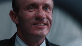 <b>Michelette:</b> - McCandless is no more.
<b>Furlong:</b> - Wait... I'm McCandless. Nice try, Mark, but I made it. I completed the transfer.
<b>Michelette:</b> - Don't you give me that shit.
<b>Furlong:</b> - Shoot him, Vacendak. He tried to assassinate me.
<b>Michelette:</b> - You take orders from a Freejack?
<b>Vacendak:</b> - Who is he?
<b>engineer:</b> - There were 22.762 seconds of transfer before it blew off-line.
<b>Vacendak:</b> - Is he McCandless?
<b>Furlong:</b> - Of course I am.
<b>engineer:</b> - We've completed transfers in that time... and we've had them take longer. I don't know.
<b>Vacendak:</b> - Mr. McCandless will have to identify himself. We can't get a voice-print lock. A ret scan won't work.
<b>Michelette:</b> - He is lying! Check his personal I.D. number! Only McCandless would know that!
<b>Vacendak:</b> - Well?
<b>Michelette:</b> - What more do you want? Shoot him, Vacendak!
<b>Furlong:</b> - Six.
<b>Vacendak:</b> - Correct. Continue.
<b>Furlong:</b> - Nine.
<b>Vacendak:</b> - Proceed.
<b>Furlong:</b> - Two. Seven. Five, seven. Five, four, six, nine, seven!
<b>Michelette:</b> - Goddamn you, McCandless!